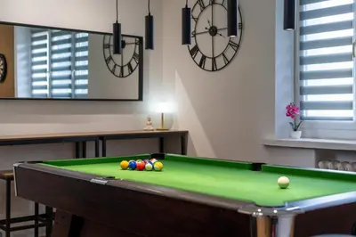 a room with a pool table and a clock at Zabłocie Comfort House with parking and garden in Kraków