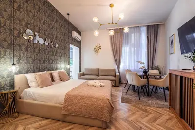 a bedroom with a large bed and a dining room at Golden Apartment by Cracovia Prime in Kraków