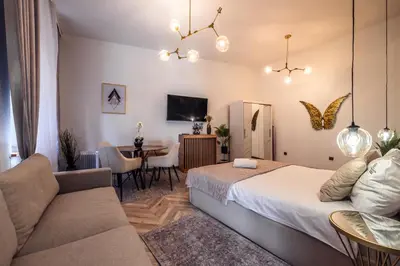 a bedroom with a bed and a couch and a table at Golden Apartment by Cracovia Prime in Kraków