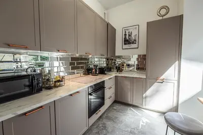 a kitchen with white cabinets and a microwave at Golden Apartment by Cracovia Prime in Kraków