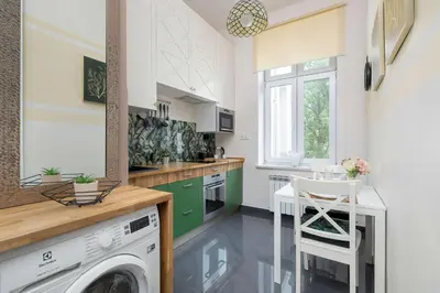 a kitchen with a washer and dryer and a washing machine at Charming Apartments with Desk in Downtown Cracow by Noclegi Renters in Kraków