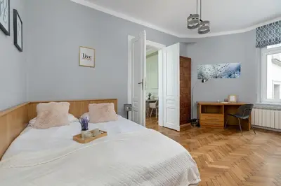 a bedroom with a white bed and a desk at Charming Apartments with Desk in Downtown Cracow by Noclegi Renters in Kraków