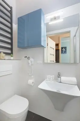 a bathroom with a white toilet and a sink at Charming Apartments with Desk in Downtown Cracow by Noclegi Renters in Kraków