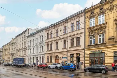 a row of buildings on a street with parked cars at Charming Apartments with Desk in Downtown Cracow by Noclegi Renters in Kraków