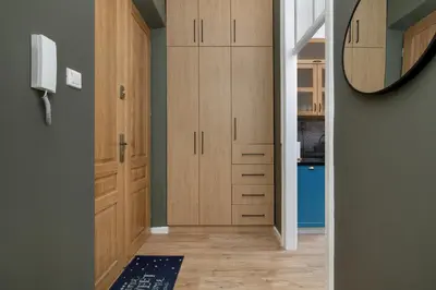 a hallway with wooden cabinets and a mirror at Charming Apartments with Desk in Downtown Cracow by Noclegi Renters in Kraków