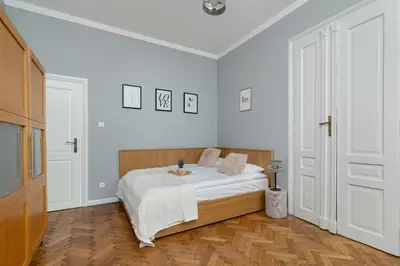 a white bedroom with a bed with white sheets at Charming Apartments with Desk in Downtown Cracow by Noclegi Renters in Kraków