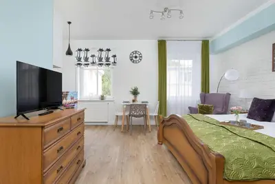 a bedroom with a bed and a television on a dresser at Starowiślna Cozy Studio in Downtown Cracow by Noclegi Renters in Kraków