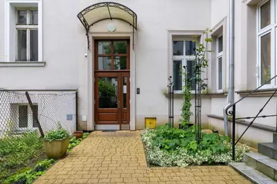 a house with a wooden door and a patio at Starowiślna Cozy Studio in Downtown Cracow by Noclegi Renters in Kraków