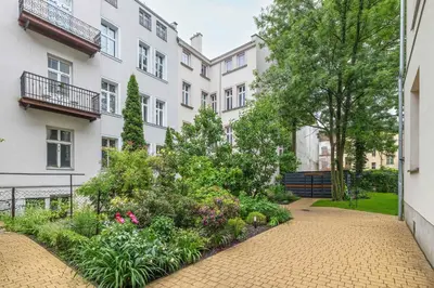 a courtyard with a garden in front of a building at Starowiślna Cozy Studio in Downtown Cracow by Noclegi Renters in Kraków
