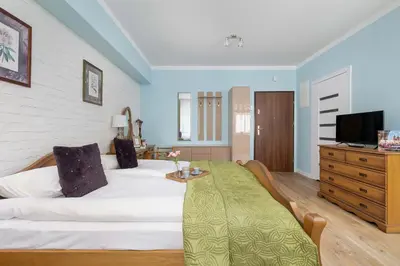 a bedroom with a bed and a dresser with a tv at Starowiślna Cozy Studio in Downtown Cracow by Noclegi Renters in Kraków