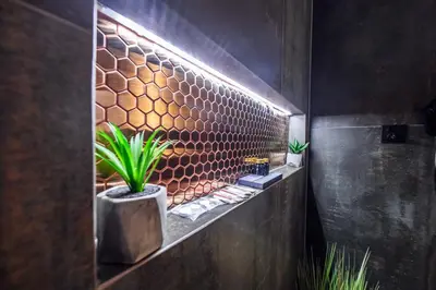 a bathroom with a stone wall with plants on it at Copper Apartment by Cracovia Prime in Kraków