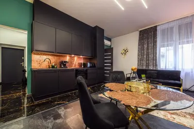 a living room with a table and a kitchen at Copper Apartment by Cracovia Prime in Kraków