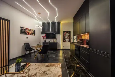 a kitchen with black cabinets and a table with chairs at Copper Apartment by Cracovia Prime in Kraków