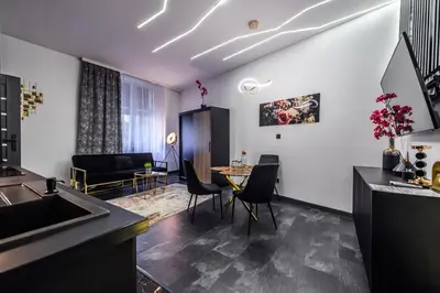 a kitchen and living room with a table and chairs at Copper Apartment by Cracovia Prime in Kraków