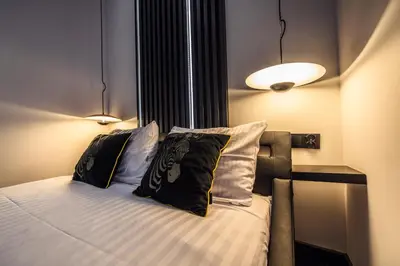 a bedroom with a bed with two pillows at Copper Apartment by Cracovia Prime in Kraków