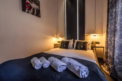 a bedroom with a bed with two towels on it at Copper Apartment by Cracovia Prime in Kraków