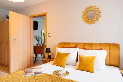 a bedroom with a large bed with yellow pillows at Honey Apartment by Cracovia Prime in Kraków