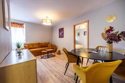 a living room with a table and a couch at Honey Apartment by Cracovia Prime in Kraków