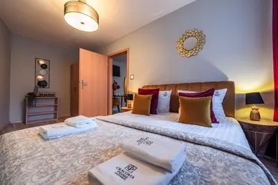 a bedroom with a large bed with towels on it at Honey Apartment by Cracovia Prime in Kraków