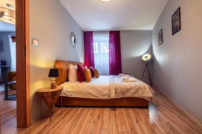a bedroom with a bed with red curtains at Honey Apartment by Cracovia Prime in Kraków