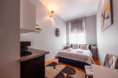 a small bedroom with a bed and a television at Loc8 Apartments by Cracovia Prime in Kraków