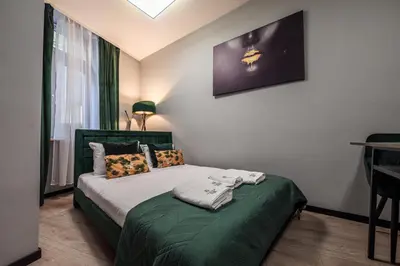 a bedroom with a bed with a green comforter at Loc8 Apartments by Cracovia Prime in Kraków
