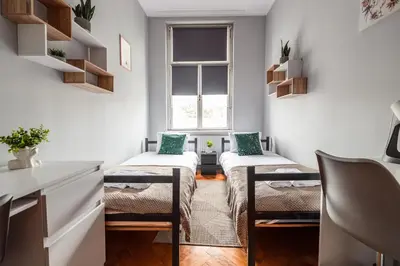 a small room with two beds and a window at Room8 Apartments by Cracovia Prime in Kraków