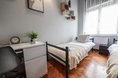 a bedroom with a bed and a desk with a clock at Room8 Apartments by Cracovia Prime in Kraków
