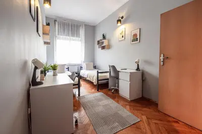 a room with a bed and a desk and a room with a door at Room8 Apartments by Cracovia Prime in Kraków