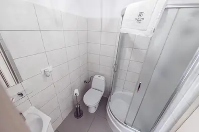 a white bathroom with a shower and a toilet at Room8 Apartments by Cracovia Prime in Kraków