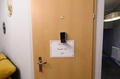 a door with a sign on it with a cell phone on it at Room8 Apartments by Cracovia Prime in Kraków