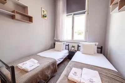 two twin beds in a room with a window at Room8 Apartments by Cracovia Prime in Kraków