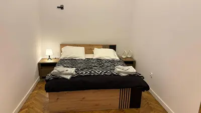 a bedroom with a large bed and two night stands at Stradom House Apartment in Kraków