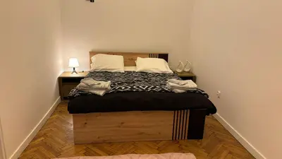 a bedroom with a large bed with a wooden headboard at Stradom House Apartment in Kraków