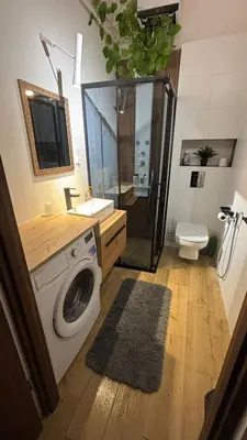 a bathroom with a shower and a washing machine at Stradom House Apartment in Kraków
