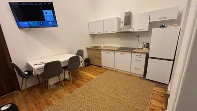 a small kitchen with a table and a refrigerator at Stradom House Apartment in Kraków