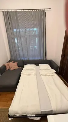 a bed sitting in a room with a window at Stradom House Apartment in Kraków