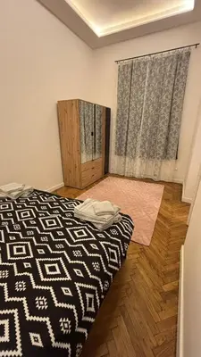 a bedroom with a black and white bed and wooden floors at Stradom House Apartment in Kraków