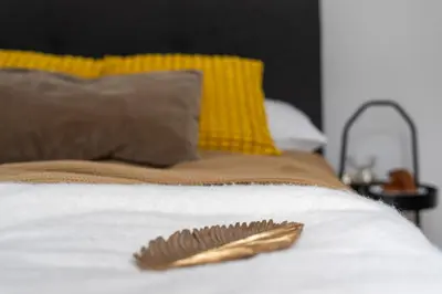 a white bed with a gold decoration on it at Near Wawel Castle in Kraków
