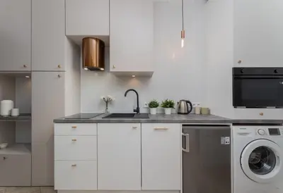 a white kitchen with a sink and a dishwasher at Near Wawel Castle in Kraków
