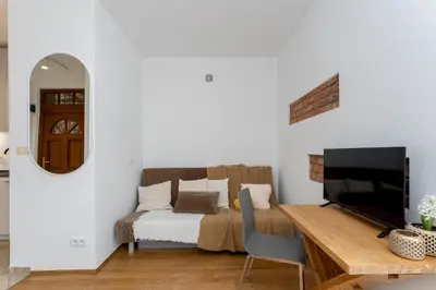 a bedroom with a bed and a desk with a television at Near Wawel Castle in Kraków