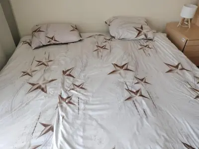 a white bed with wooden stars on it at Quiet in the City Wrocławska in Kraków