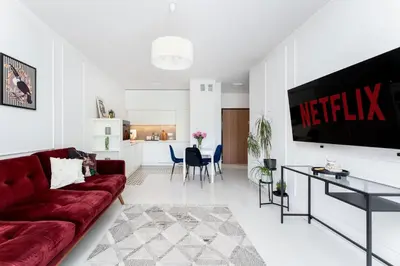 a living room with a red couch and a kitchen at Malila Premium Apartments Cracow Tauron Arena Lema 15E in Kraków