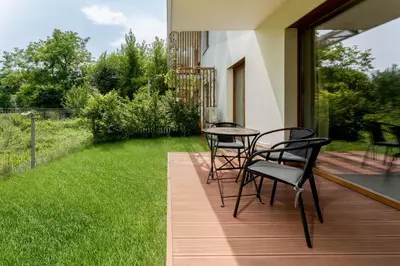 a patio with chairs and a table and a lawn at Malila Premium Apartments Cracow Tauron Arena Lema 15E in Kraków