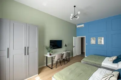 a bedroom with two beds and a desk in it at Kaleidoscope Apartment by Tyzenhauz in Kraków