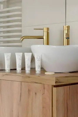 a bathroom with a sink and four cups on a counter at Kaleidoscope Apartment by Tyzenhauz in Kraków