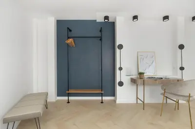 a room with a blue wall with a bench and a table at Kaleidoscope Apartment by Tyzenhauz in Kraków