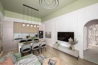 a kitchen and living room with a table and chairs at Kaleidoscope Apartment by Tyzenhauz in Kraków