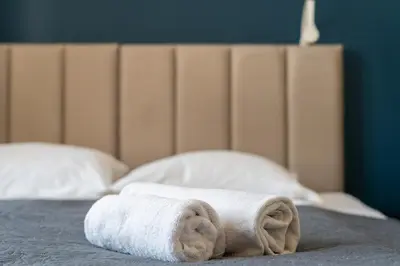 a stack of towels sitting on top of a bed at Old Market View Premium Standard with AC in Kraków
