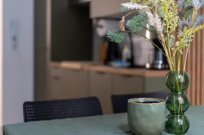 a vase with flowers and a cup on a table at Old Market View Premium Standard with AC in Kraków
